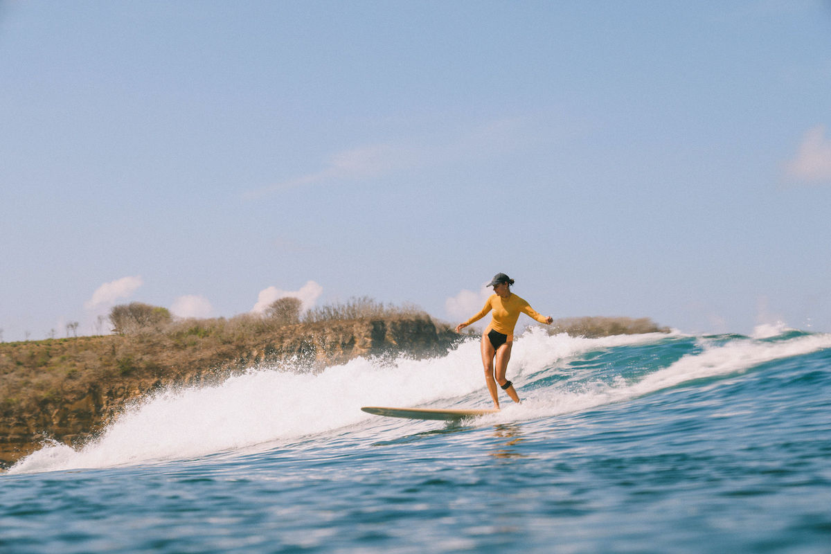 Girl surfing at the surf & yoga retreat in Lombok