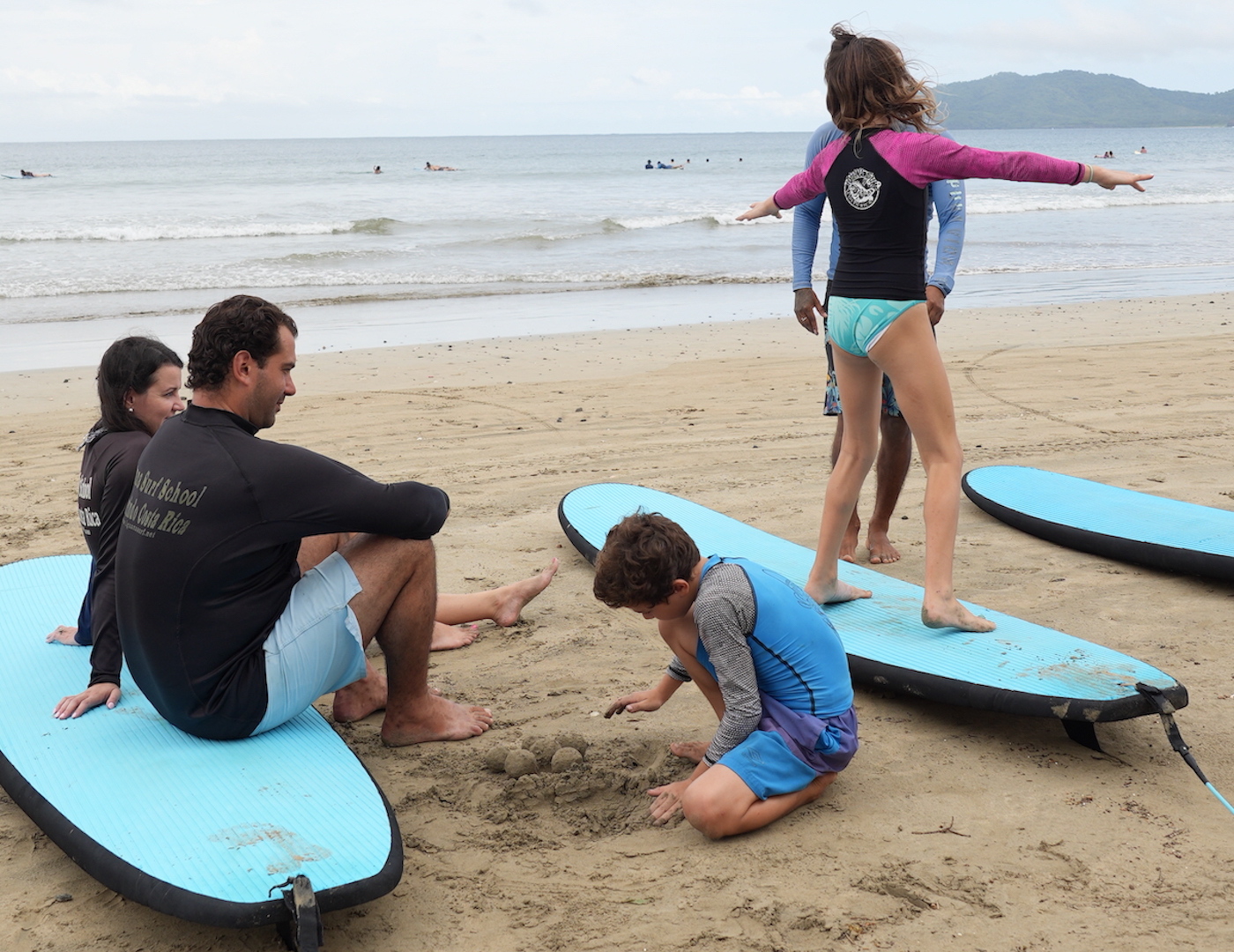 Iguana Surf - A family being taught a surf lesson on the beach. 