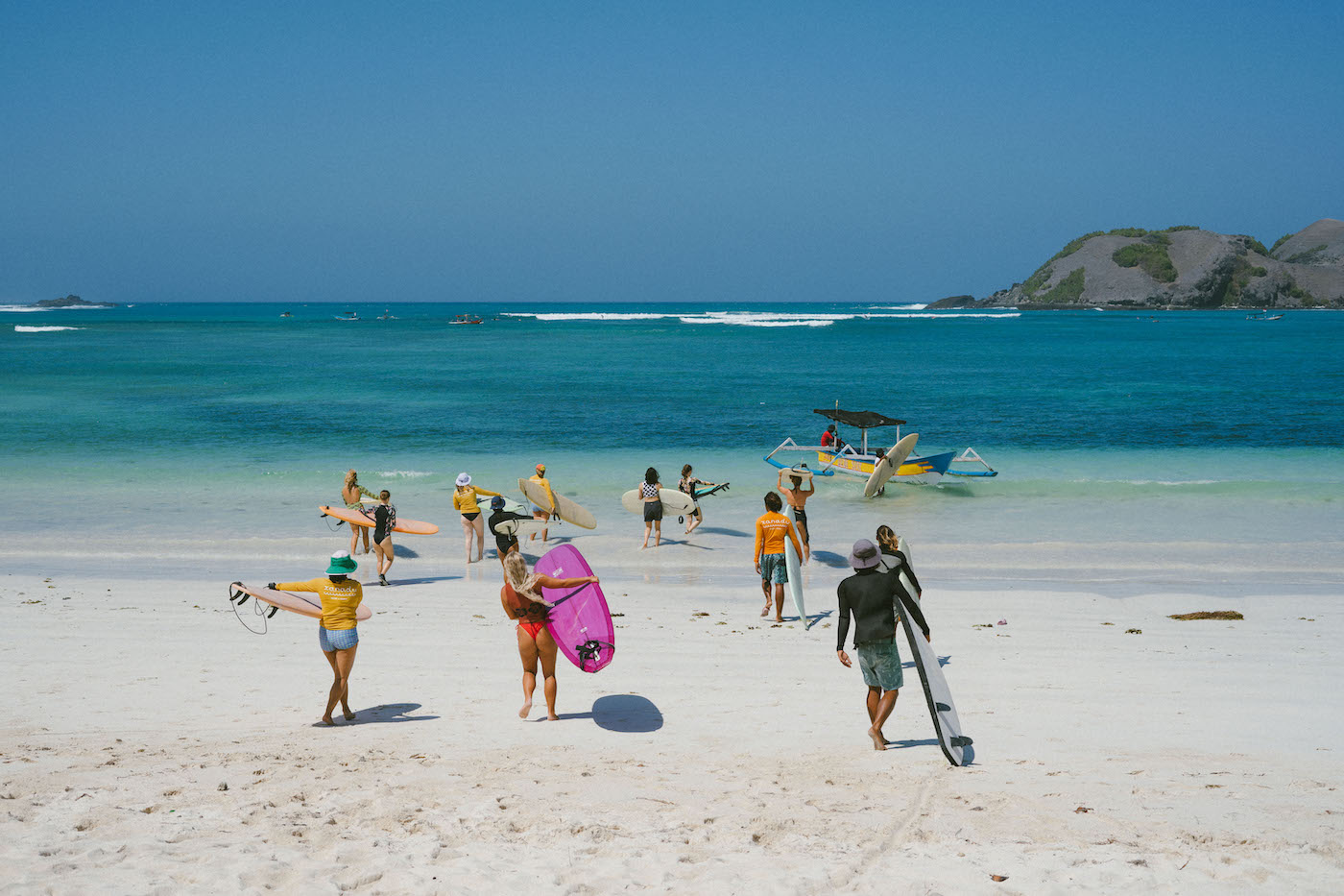 Xanadu surf and yoga - the surfers all walking out into the ocean. 