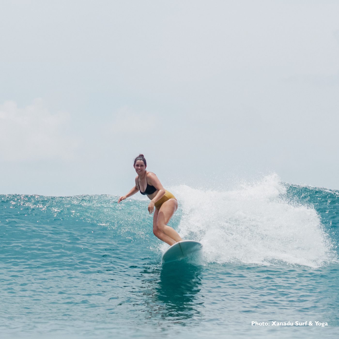 A female surfer at Xanadu Surf & Yoga A girl progressing her surfing on a wave at Xanadu Surf & Yoga