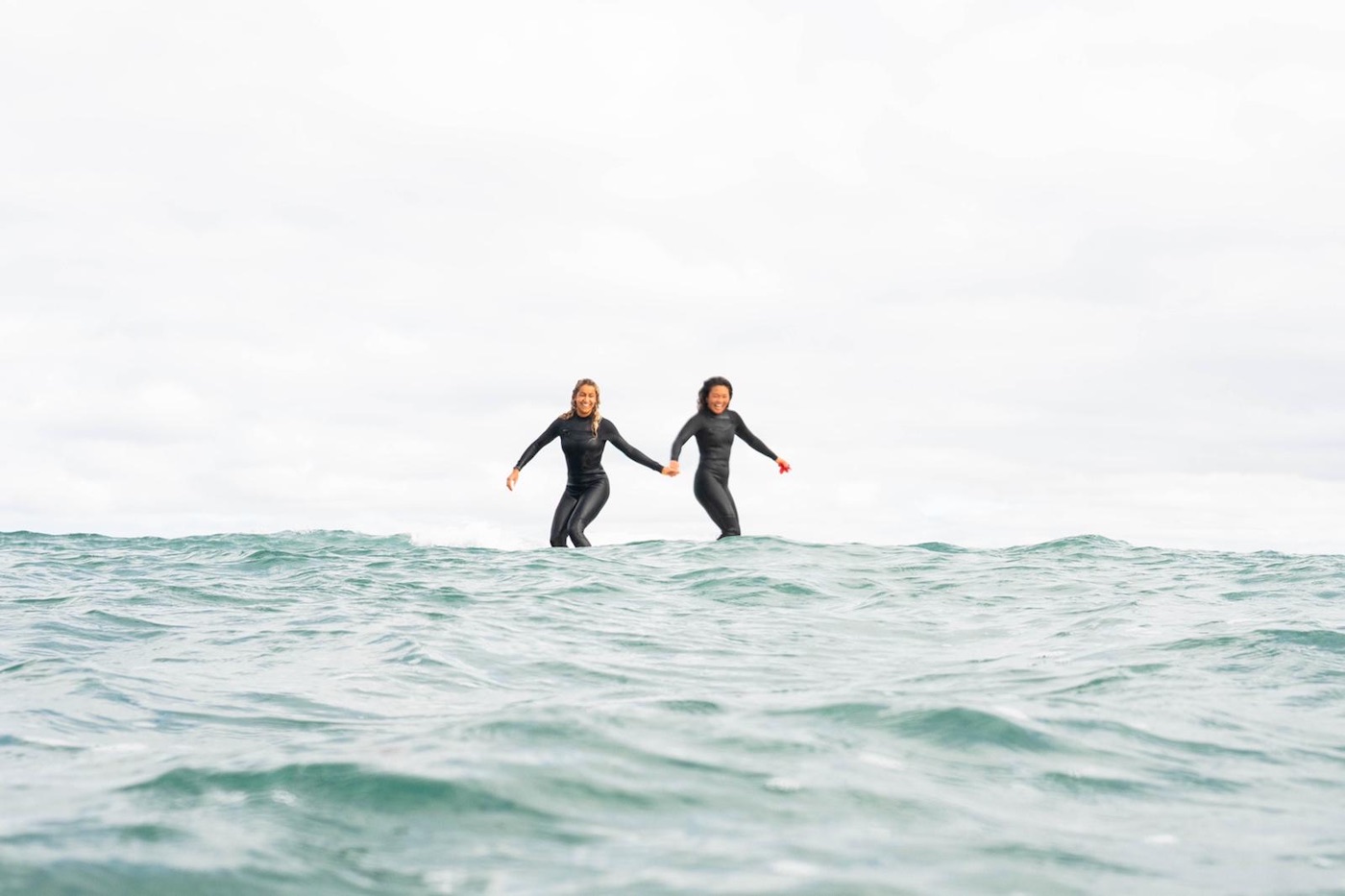 Two girls surfing together at Yume Surfcamps