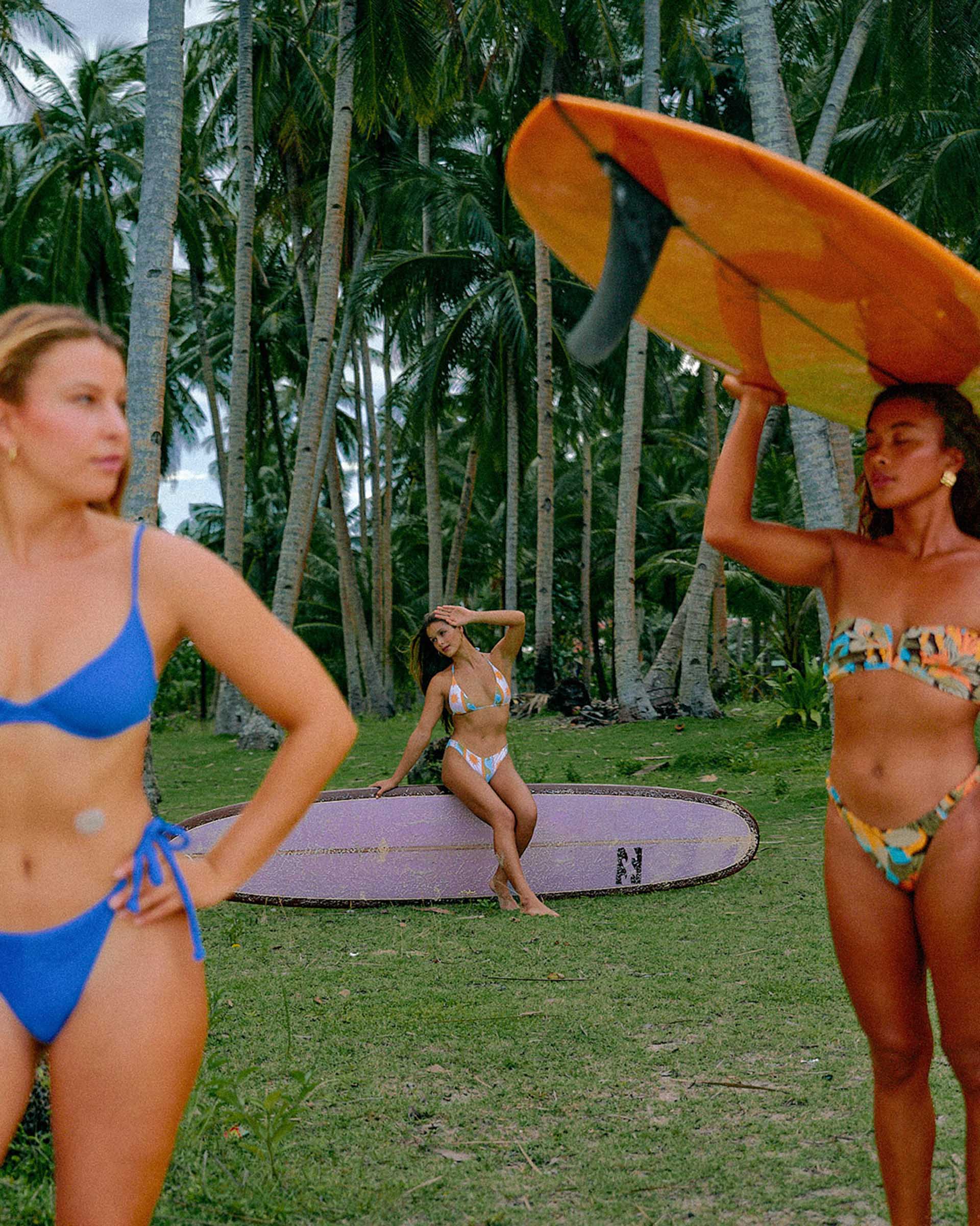 Three surfers in bikinis