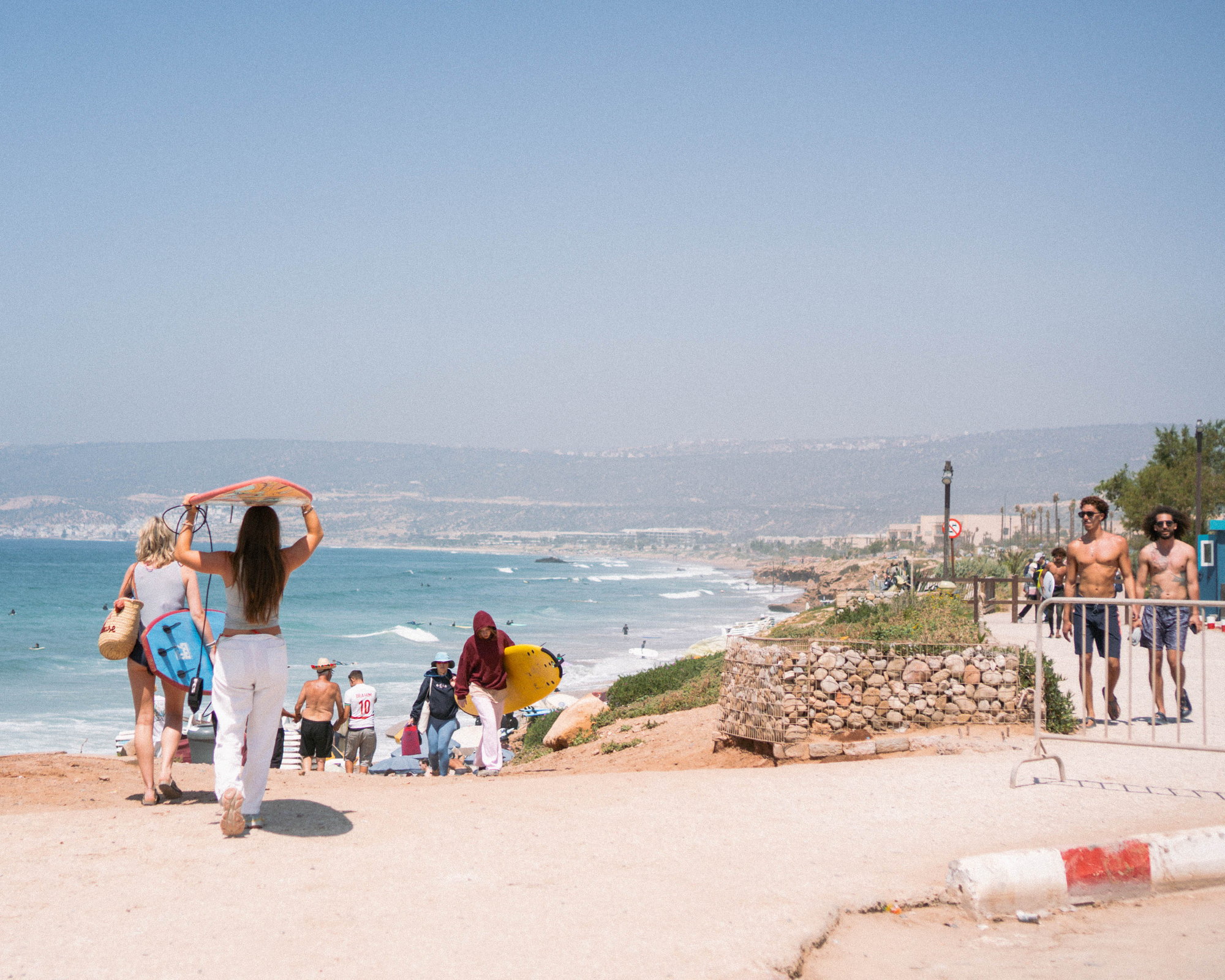 Surfers carrying boards down to the beach at Tamraght on Morocco's Atlantic coast