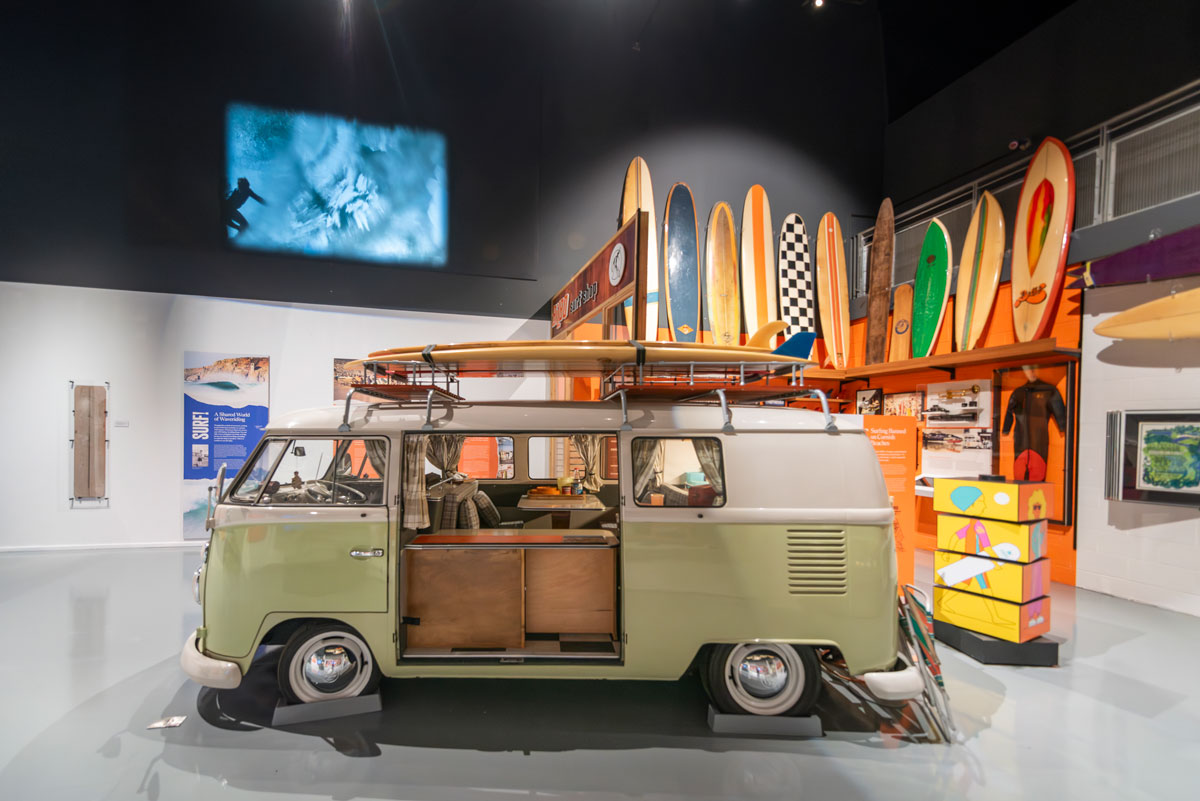 A vintage VW camper van and surfboards in the SURF! exhibition at the National Maritime Museum Cornwall